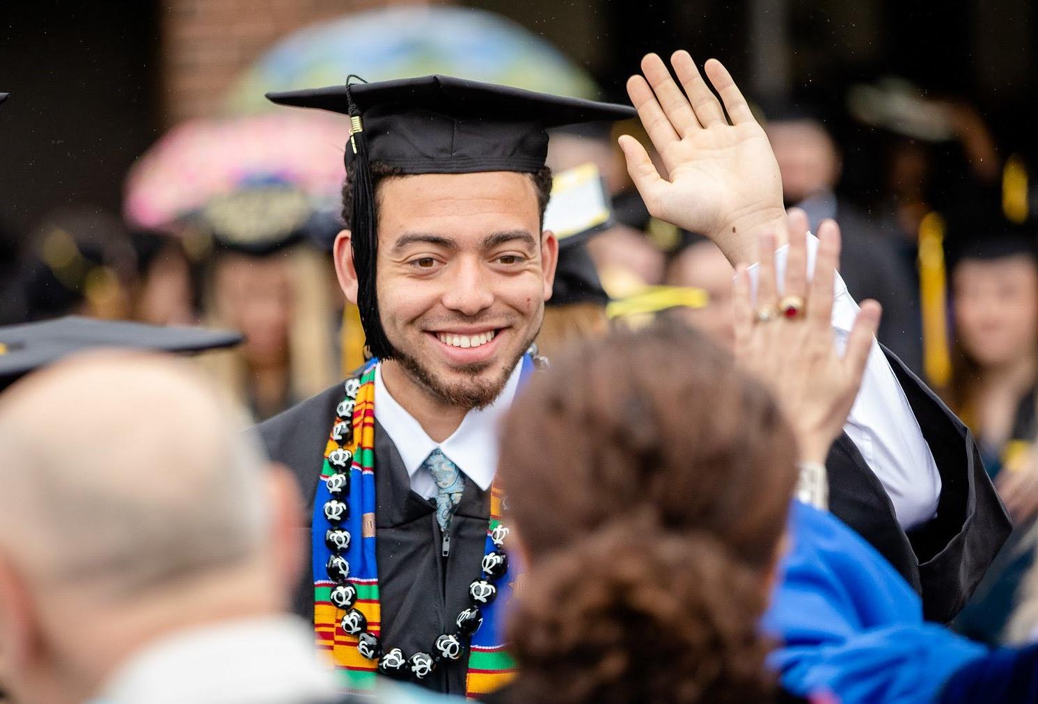 Student graduating giving a high five